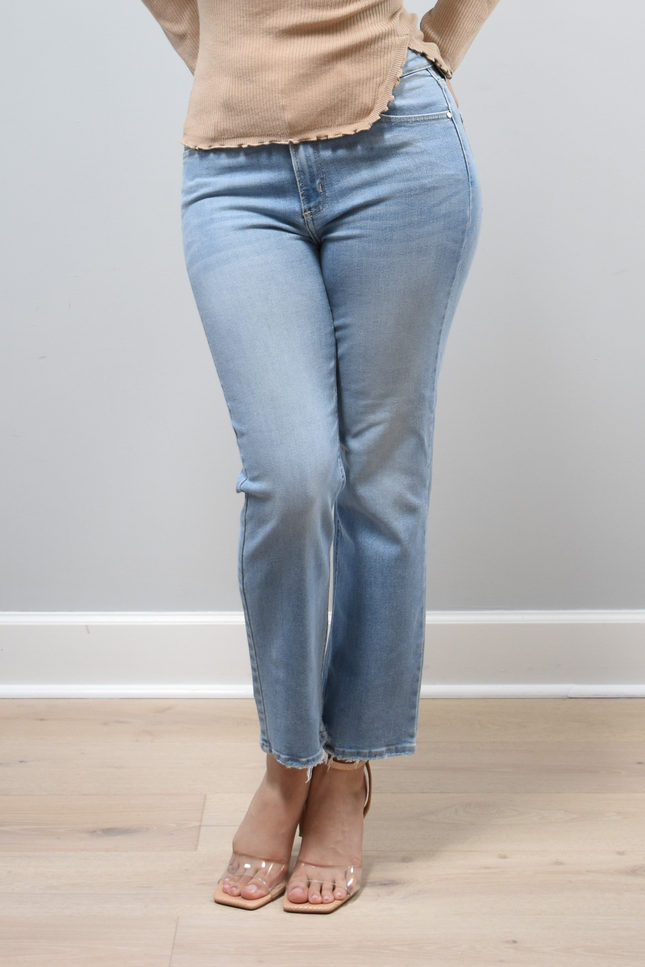 Light-wash straight-leg jeans with mid-high rise shown from the front on model, styled with neutral top.