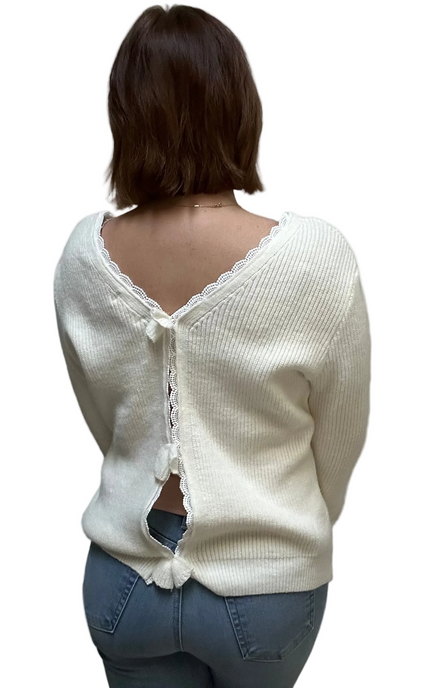 Grace Bow-Back Sweater in off white with lace-trim V-neckline and oversized back bow – soft ribbed knit in a relaxed fit – front view on soft linen background – Justyna Grace Boutique