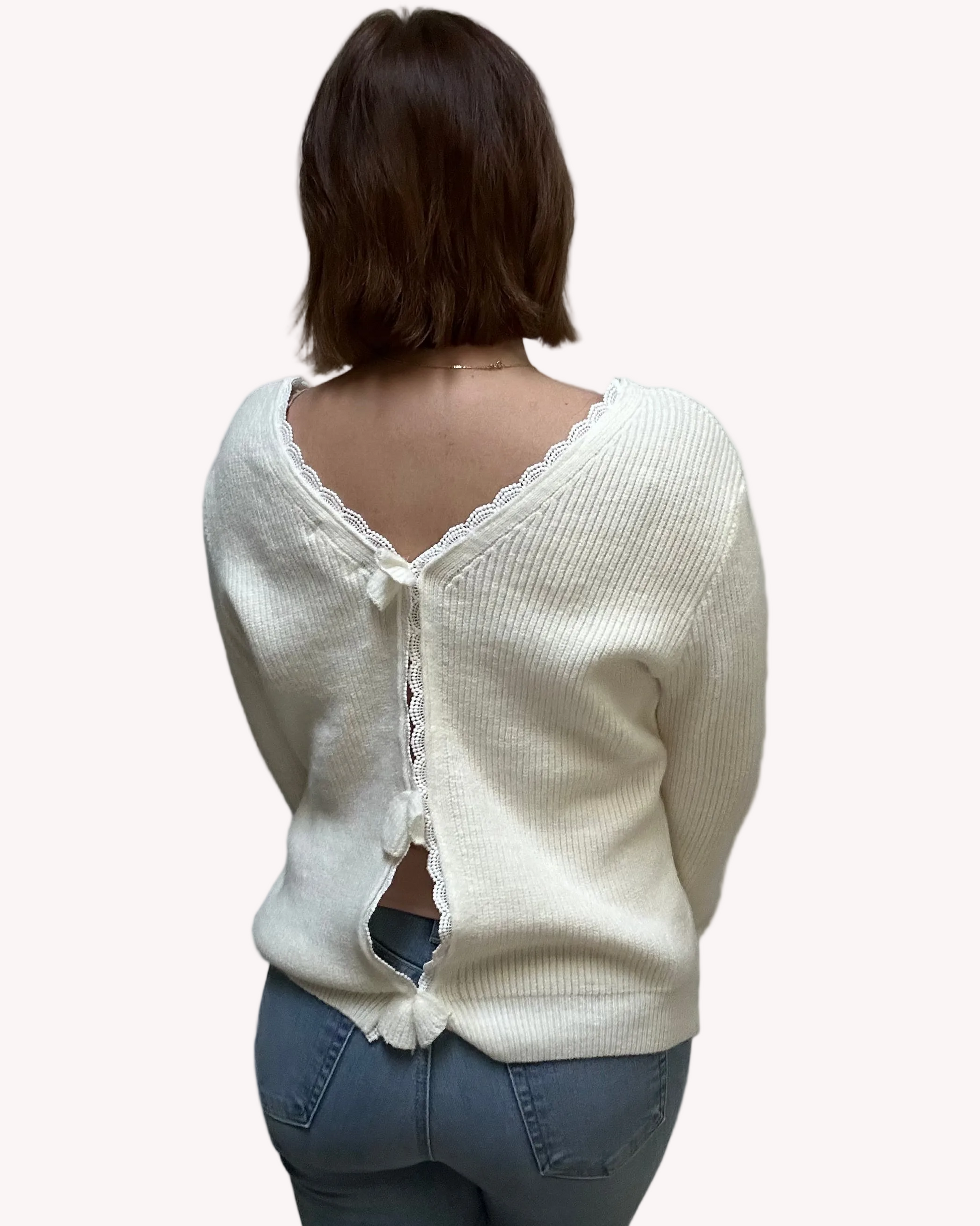 Grace Bow-Back Sweater in off white with lace-trim V-neckline and oversized back bow – soft ribbed knit in a relaxed fit – front view on soft linen background – Justyna Grace Boutique