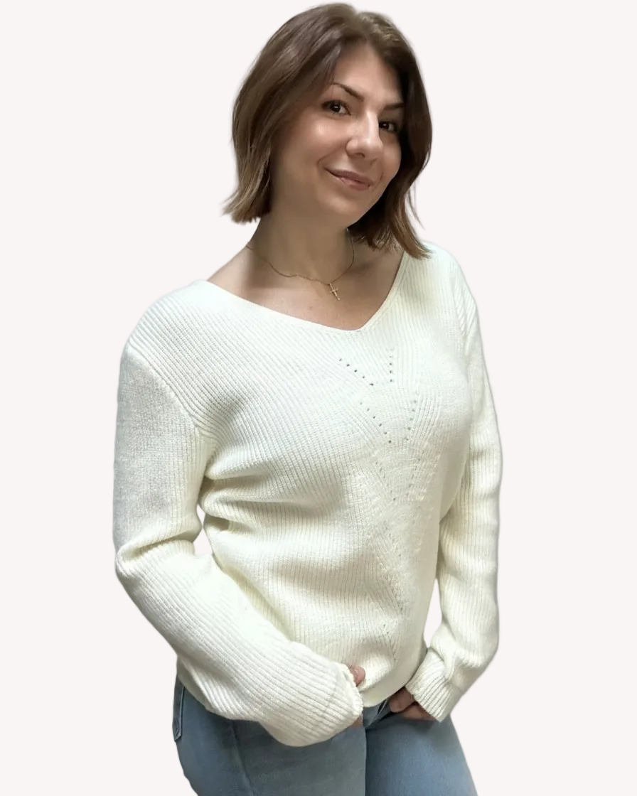 Off-white ribbed sweater with lace-trim V-neckline and oversized bow detail draping down the back, photographed on a Soft Linen background for Justyna Grace Boutique.