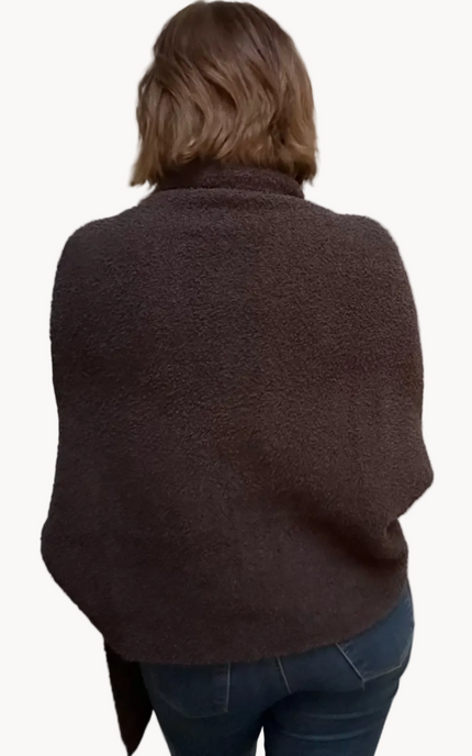 Espresso brown boucle knit poncho with open-front shawl collar, asymmetrical hem, fitted long sleeves, and front patch pockets – relaxed flowing silhouette – front view on soft linen background – Justyna Grace Boutique