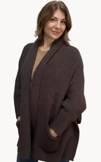Espresso brown boucle knit poncho with open-front shawl collar, asymmetrical hem, fitted long sleeves, and front patch pockets – relaxed flowing silhouette – front view on soft linen background – Justyna Grace Boutique