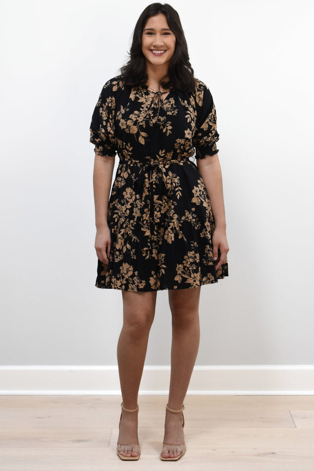 Kelly Mini Dress on soft linen background, featuring a ruffle neckline with tie and lightweight cotton–rayon fabric.