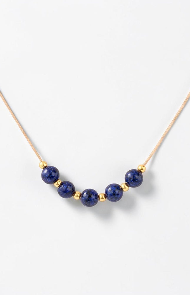 Detailed macro shot of the natural 4.36mm lapis lazuli beads alternating with small gold accents across the center span.