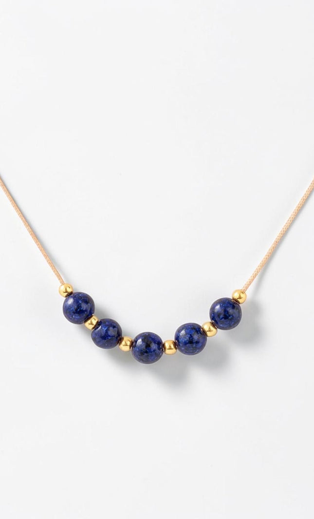 Detailed macro shot of the natural 4.36mm lapis lazuli beads alternating with small gold accents across the center span.