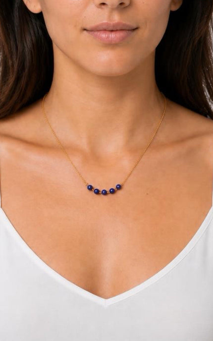 Front portrait view of the Lapis Lazuli Dainty Bead Necklace worn on a model from Justyna Grace Boutique, illustrating how the deep blue center beads sit perfectly along the collarbone.