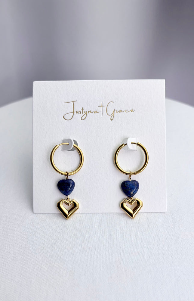 Lapis lazuli and gold heart dangle hoop earrings arranged on a professional display card, showcasing the full 46mm drop design.