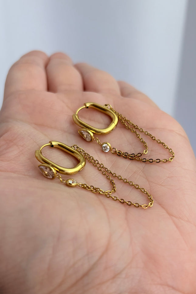 Gold drop hoop earrings with layered chain detail held in hand showing scale, drop length, and 18k gold PVD finish