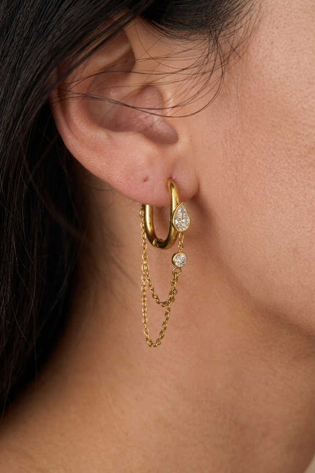 Layered chain drop hoop earrings worn on ear showing feminine silhouette and light-catching movement detail