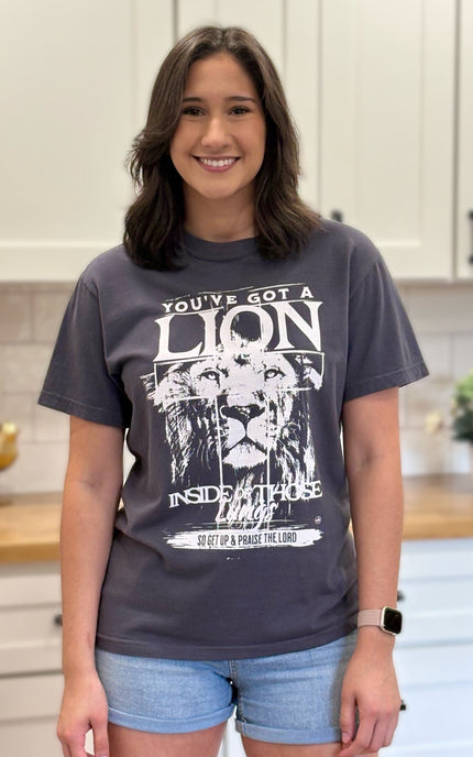 Graphite Comfort Colors tee with “You’ve Got a Lion Inside Those Lungs” worship lyric design, unisex fit and vintage finish.