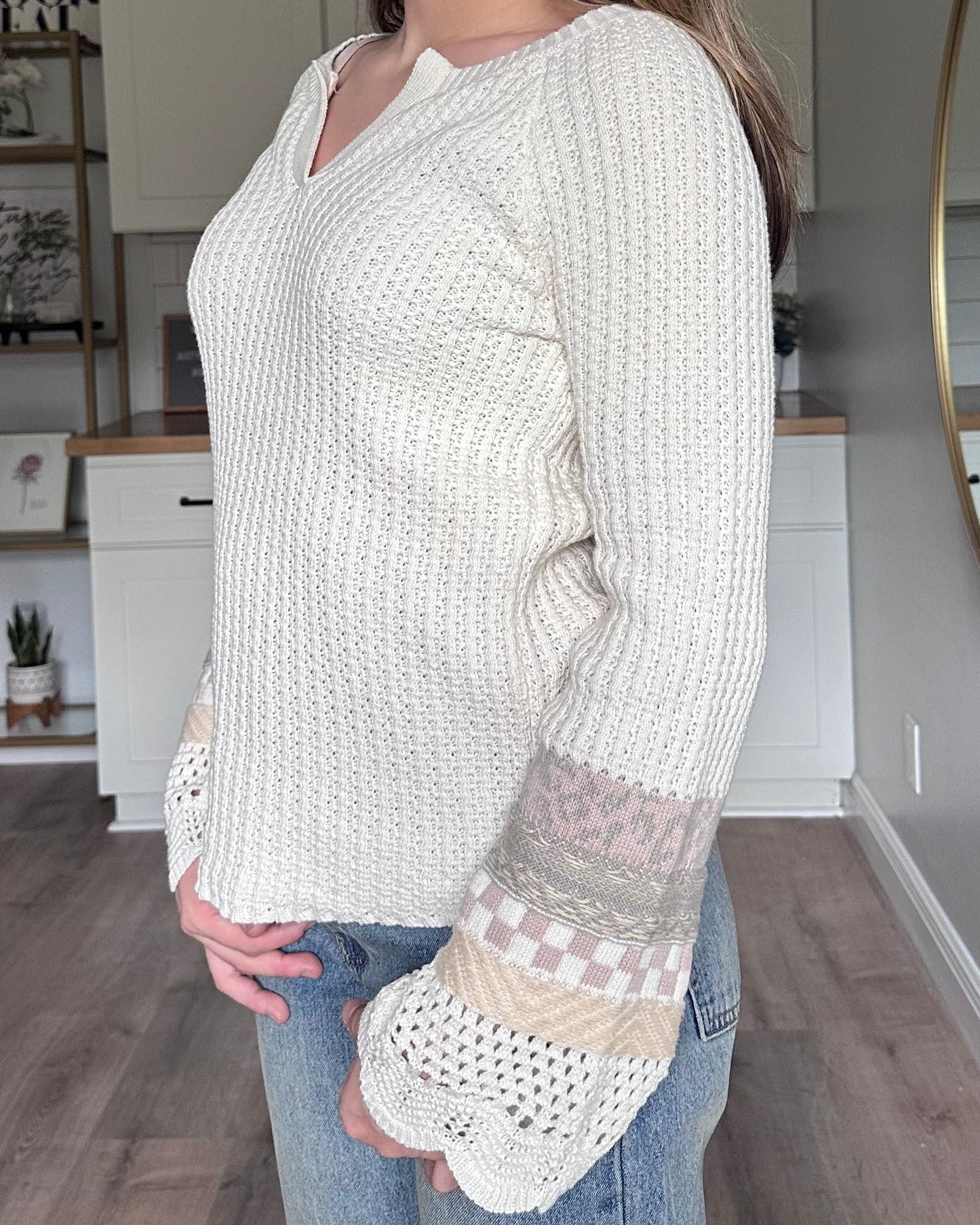 Detail view of the Margot sweater mixed media bell sleeves with scalloped edges