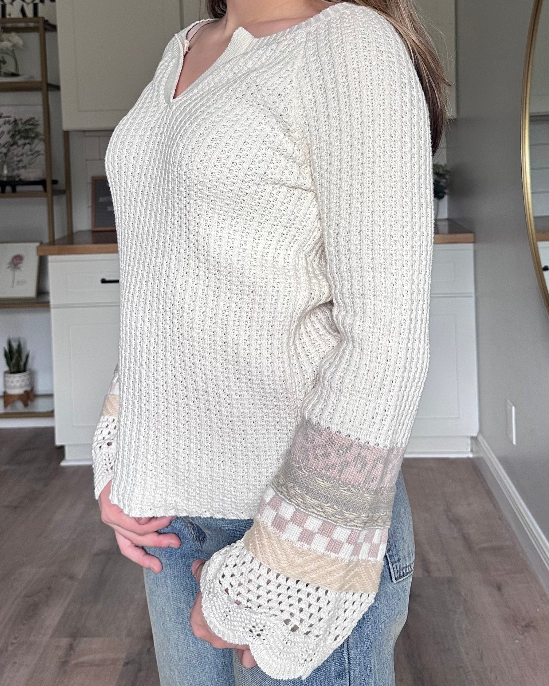 Detail view of the Margot sweater mixed media bell sleeves with scalloped edges