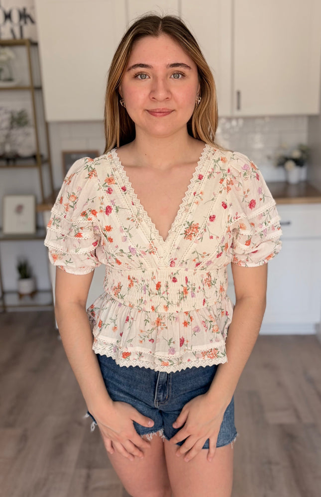 Model wearing Maribel floral eyelet peplum top with lace trim and bubble sleeves