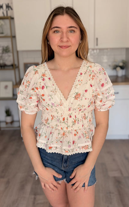 Model wearing Maribel floral eyelet peplum top with lace trim and bubble sleeves