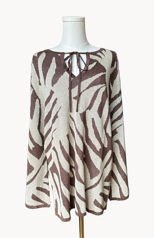 Metallic knit bell-sleeve top with front tie detail and subtle shimmer, relaxed fit and lightweight yarn, photographed on Soft Linen background.