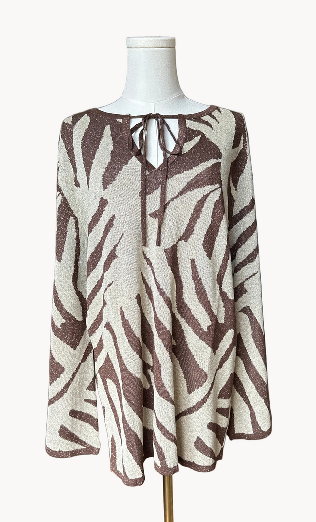 Metallic knit bell-sleeve top with front tie detail and subtle shimmer, relaxed fit and lightweight yarn, photographed on Soft Linen background.