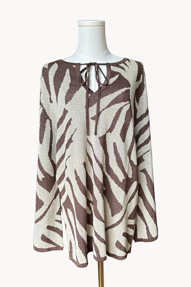 Metallic knit bell-sleeve top with front tie detail and subtle shimmer, relaxed fit and lightweight yarn, photographed on Soft Linen background.