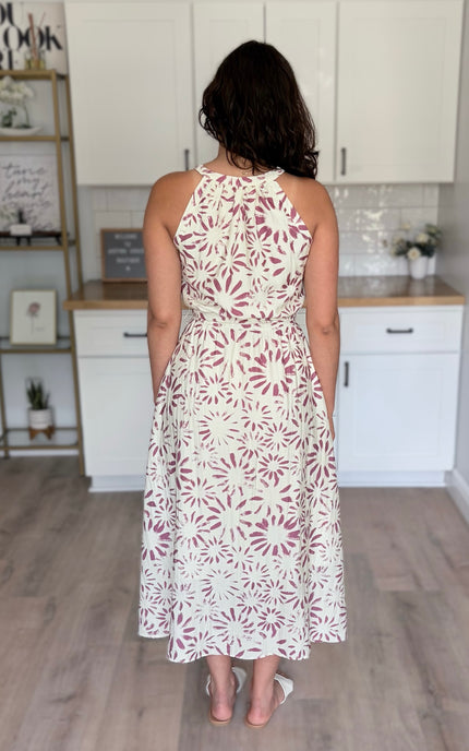 Back view of abstract floral halter dress with halter tie and relaxed skirt silhouette