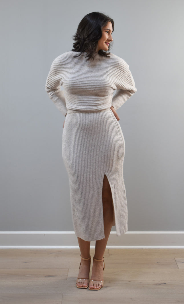 Midi one-shoulder sweater dress on soft linen background, featuring soft stretchy knit and elegant silhouette.