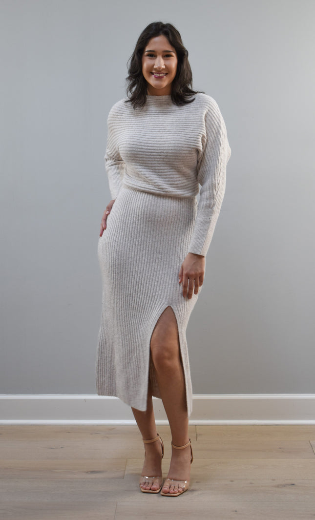 Midi one-shoulder sweater dress on soft linen background, featuring soft stretchy knit and elegant silhouette.