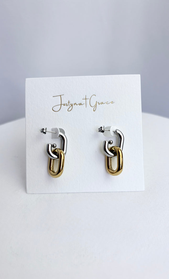 Mixed metal gold and silver link earrings displayed on jewelry card showing clean modern design and polished finish