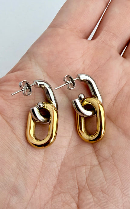 Mixed metal gold and silver link earrings held in hand showing scale, link design, and 18k gold PVD finish