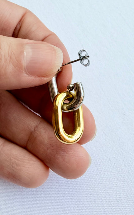 Mixed metal gold and silver link earrings held in hand showing scale, link design, and 18k gold PVD finish