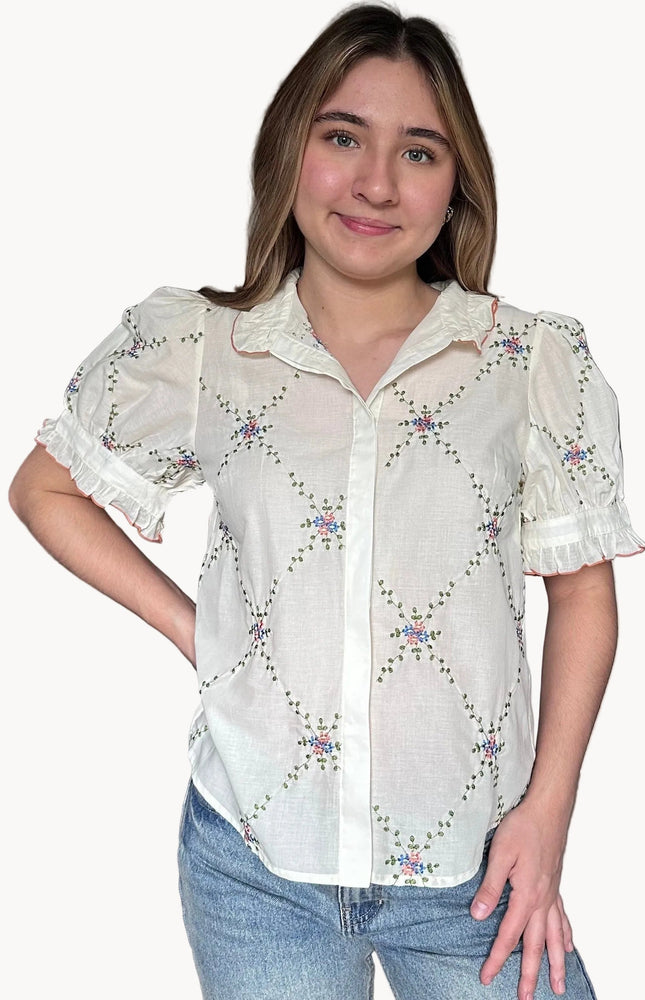 Front view of Noemi blouse ruffle collar with contrast edging and floral embroidered detail