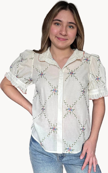 Front view of Noemi blouse ruffle collar with contrast edging and floral embroidered detail