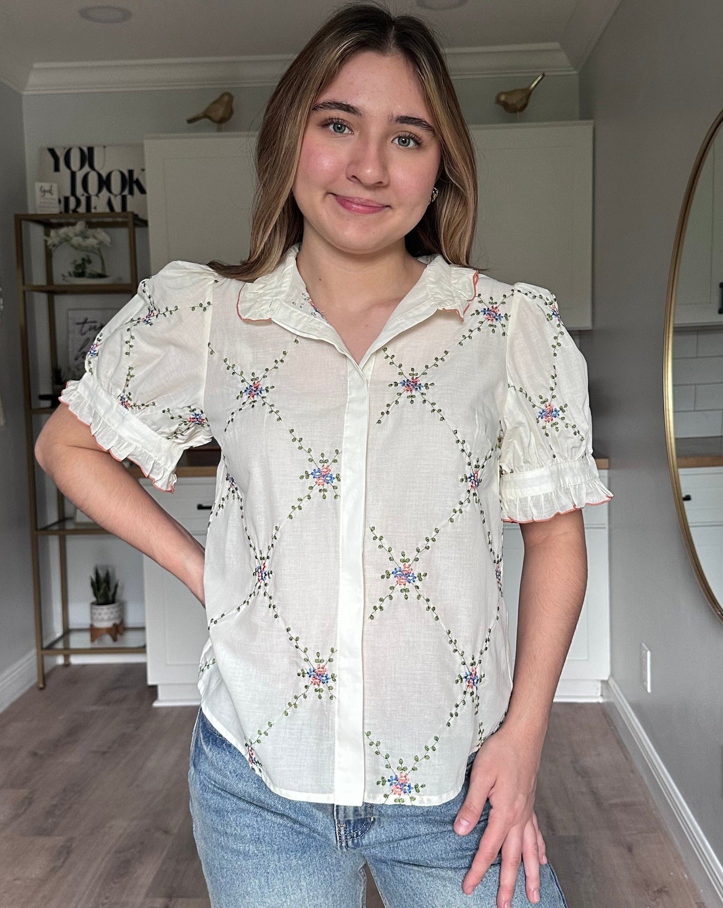 Front view of Noemi blouse ruffle collar with contrast edging and floral embroidered detail