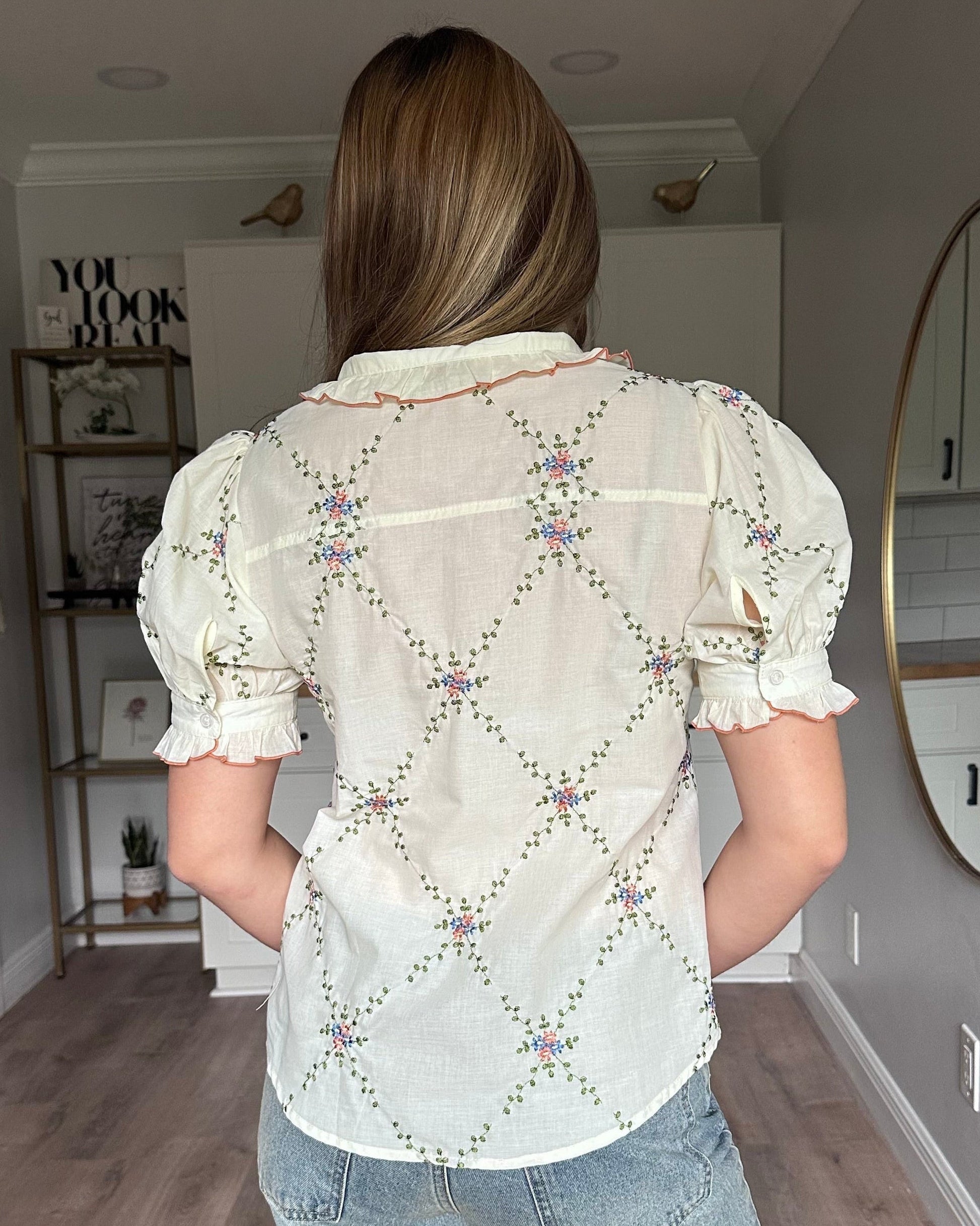 Back view of Noemi blouse ruffle collar with contrast edging and floral embroidered detail