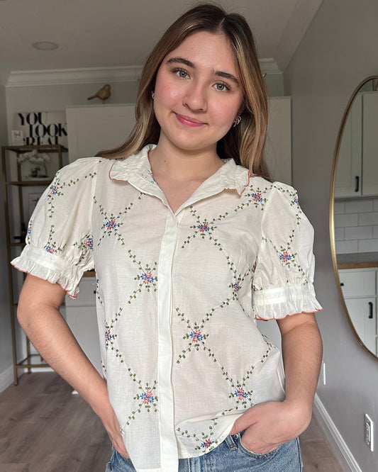 Front view of Noemi blouse ruffle collar with contrast edging and floral embroidered detail