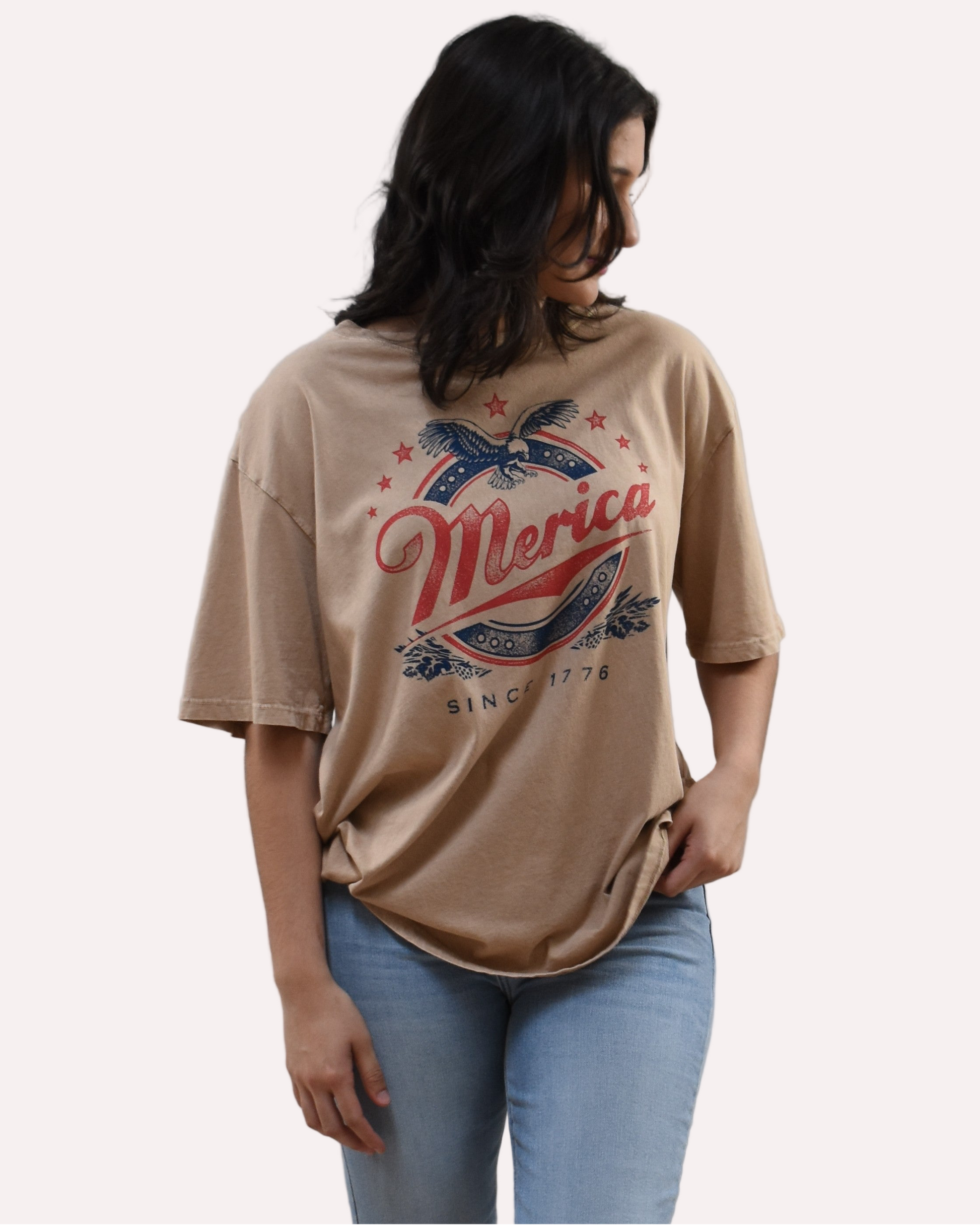 Oversized vintage graphic tee on soft linen background, featuring garment-dyed cotton and mineral-wash texture.