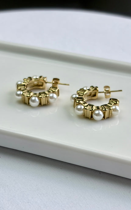 A feminine twist on a classic hoop, finished with soft glass pearls. Crafted in 18k gold PVD over 316L stainless steel for long‑lasting shine. Lightweight, hypoallergenic, waterproof, and perfect for everyday or elevated looks.