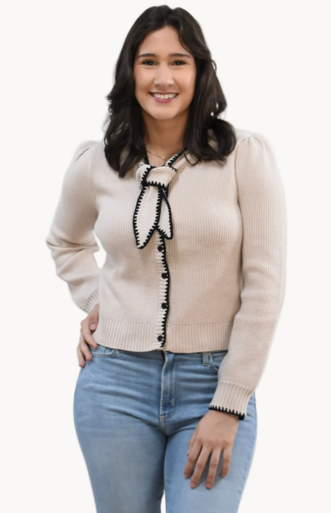 Petite Bow Knit Cardi on soft linen background, featuring a contrast-knit body and delicate bow detail at the neckline.