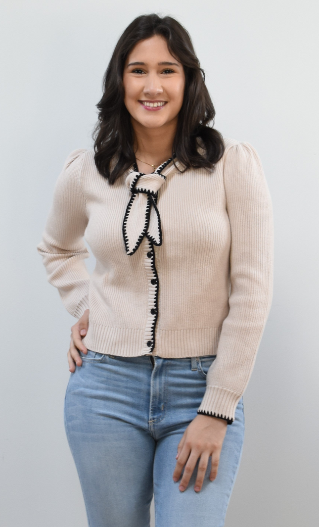 Petite Bow Knit Cardi on soft linen background, featuring a contrast-knit body and delicate bow detail at the neckline.