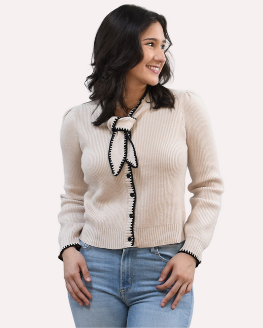 Petite Bow Knit Cardi on soft linen background, featuring a contrast-knit body and delicate bow detail at the neckline.