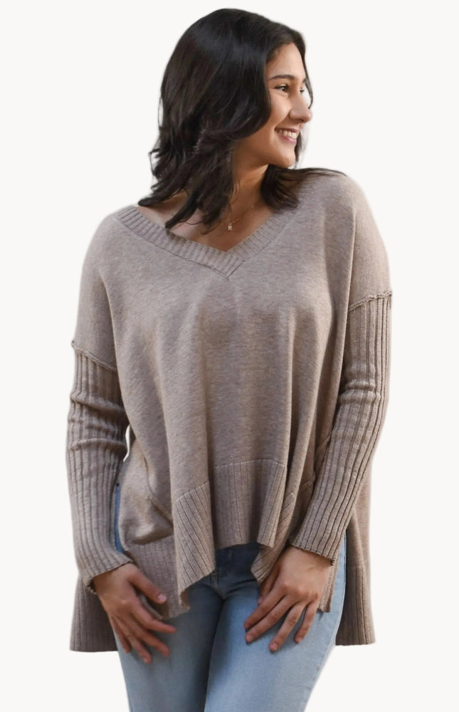 Woman wearing a beige sweater on a white background