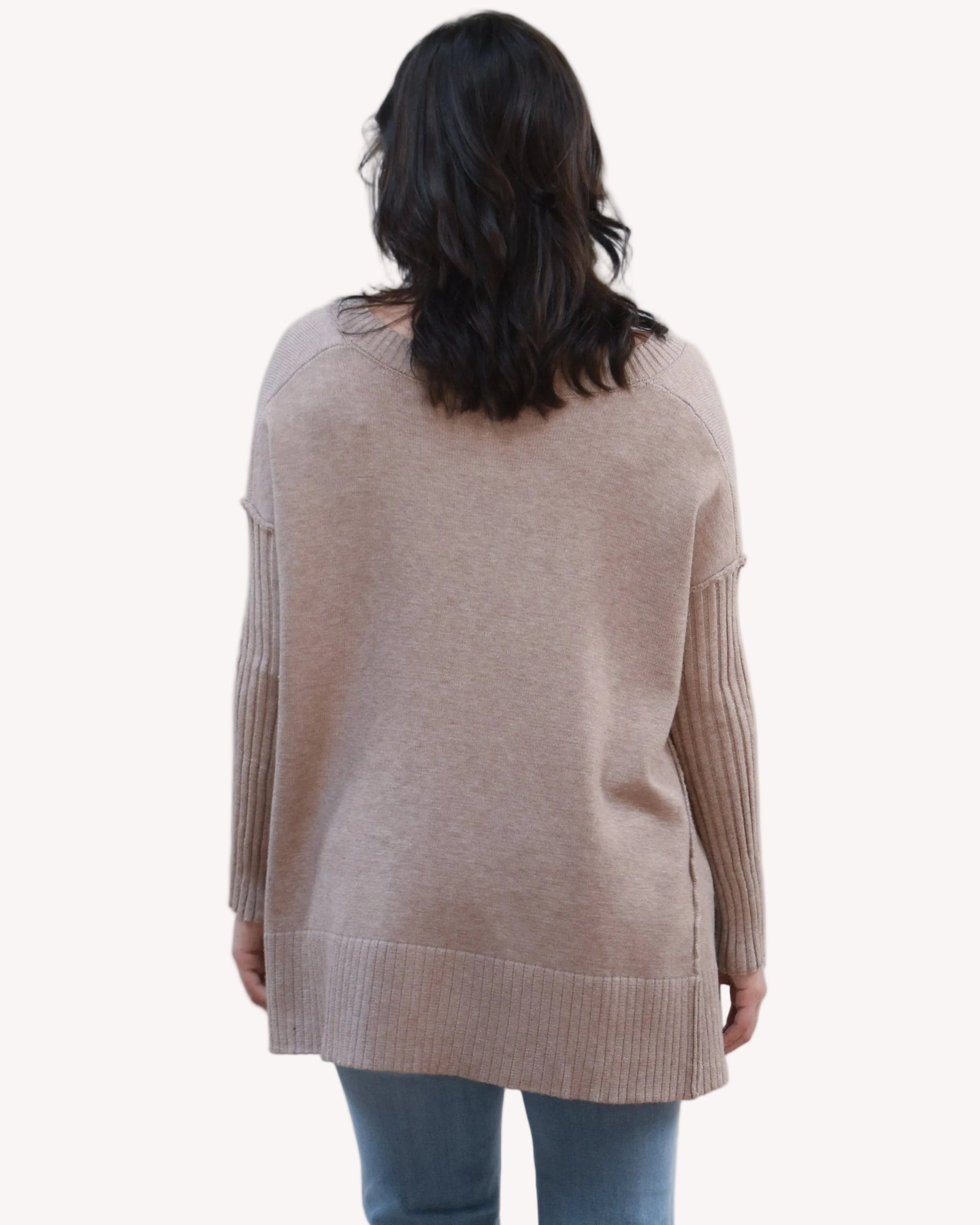 Pure Ease Ribbed V-Neck Tunic on soft linen background, featuring a smooth viscose-nylon knit and long relaxed silhouette.