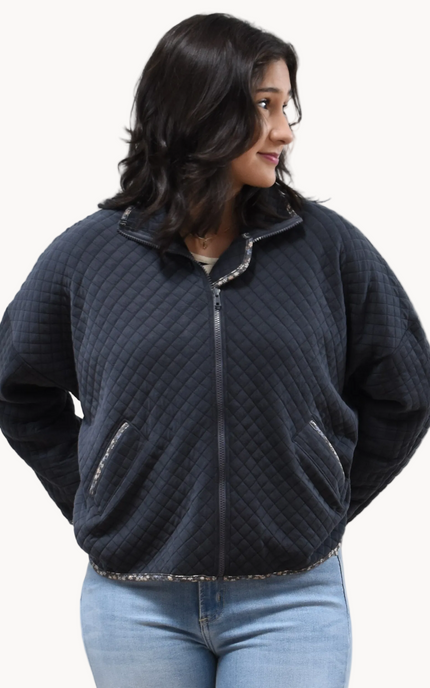 Front view of the quilted floral contrast zip-up jacket showing the mock neck, side pockets, and feminine detailing.