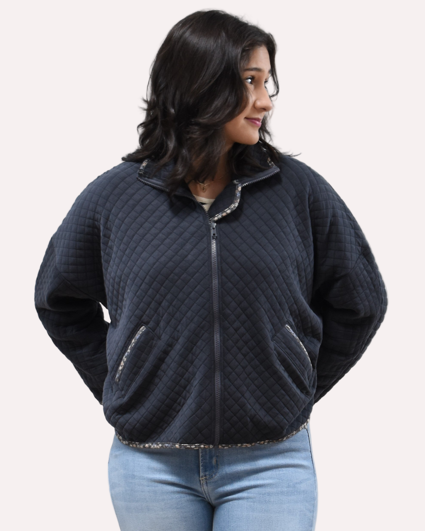 Front view of the quilted floral contrast zip-up jacket showing the mock neck, side pockets, and feminine detailing.