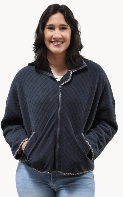 Front view of the quilted floral contrast zip-up jacket showing the mock neck, side pockets, and feminine detailing.