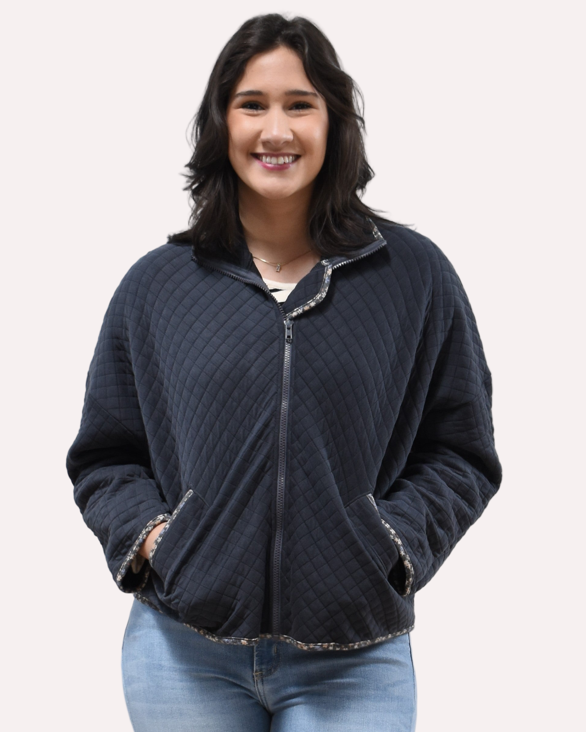 Front view of the quilted floral contrast zip-up jacket showing the mock neck, side pockets, and feminine detailing.