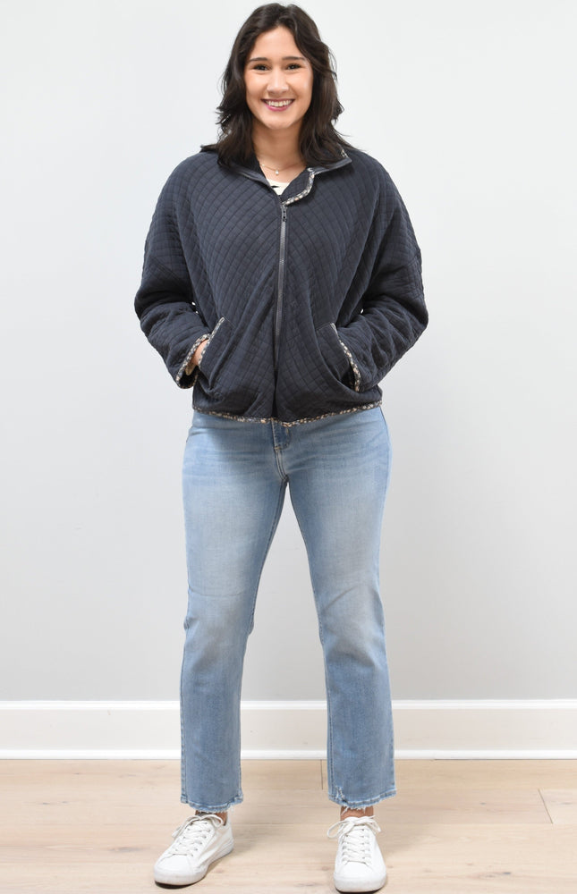Front view of the quilted floral contrast zip-up jacket showing the mock neck, side pockets, and feminine detailing.