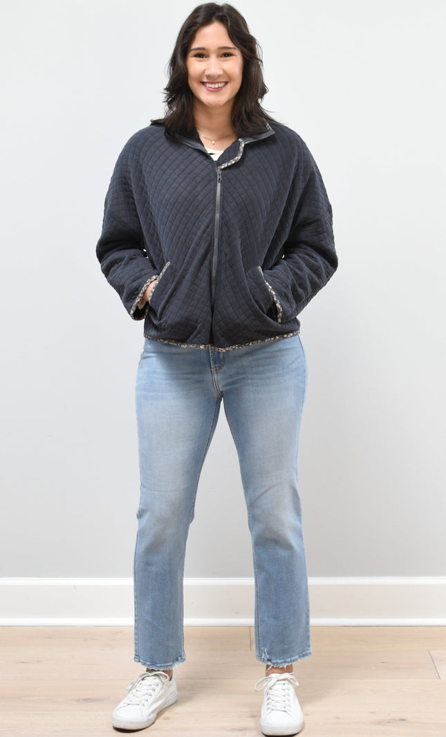 Front view of the quilted floral contrast zip-up jacket showing the mock neck, side pockets, and feminine detailing.