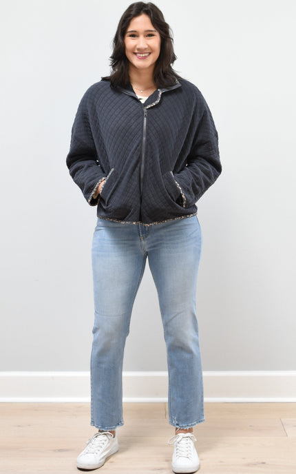 Front view of the quilted floral contrast zip-up jacket showing the mock neck, side pockets, and feminine detailing.