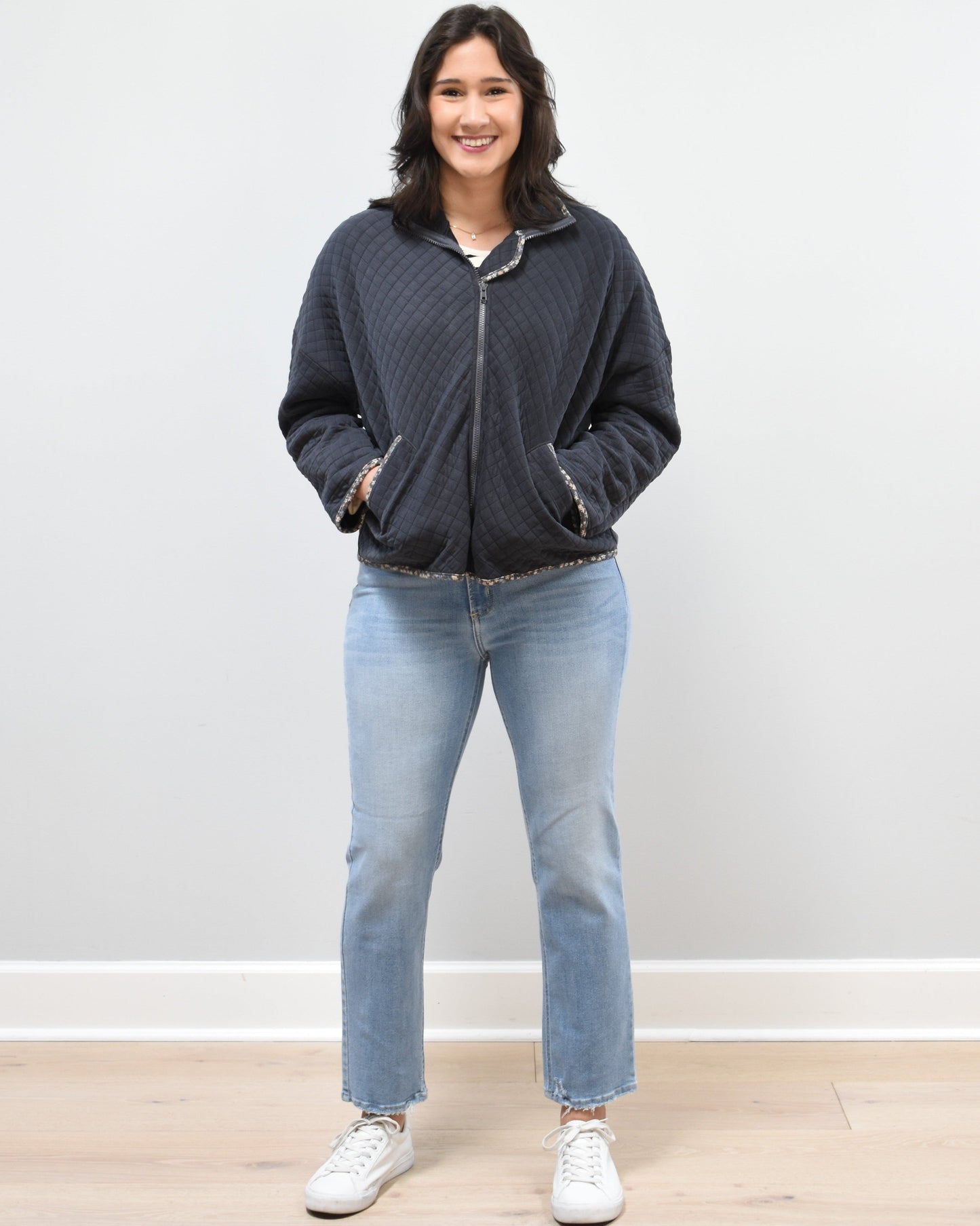 Front view of the quilted floral contrast zip-up jacket showing the mock neck, side pockets, and feminine detailing.