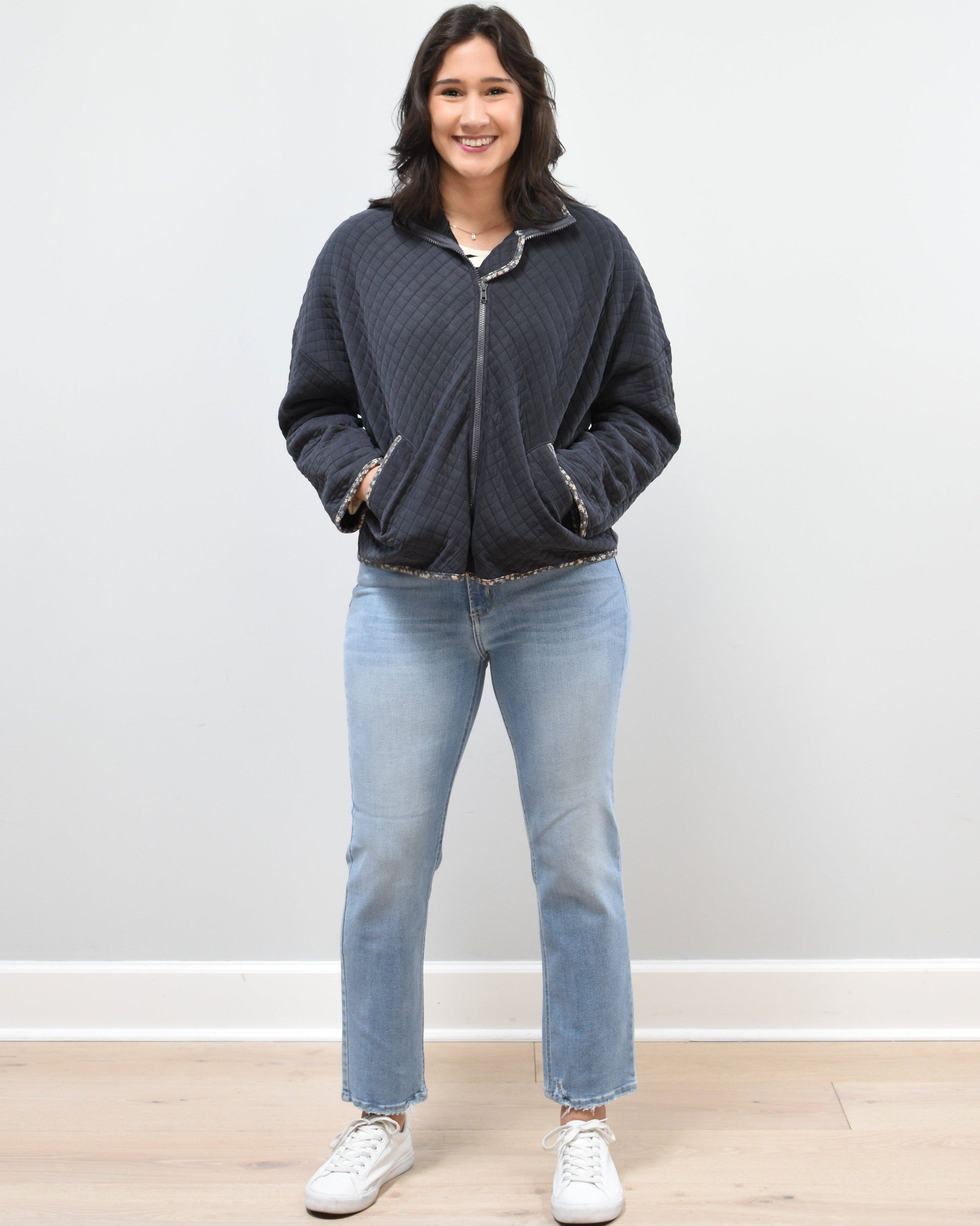 Front view of the quilted floral contrast zip-up jacket showing the mock neck, side pockets, and feminine detailing.