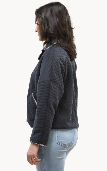 Side view of the quilted floral contrast zip-up jacket showing the mock neck, side pockets, and feminine detailing.