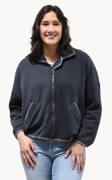 Front view of the quilted floral contrast zip-up jacket showing the mock neck, side pockets, and feminine detailing.